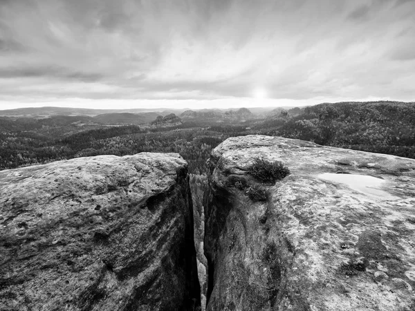 早上景色破裂的砂岩悬崖进入森林山谷，在厚厚的云层，在地平线上的太阳 hiddein. — 图库照片