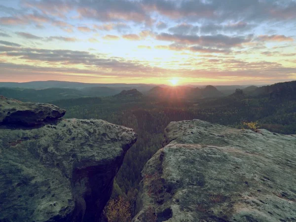 Morning view over crack sandstone edge into forest valley, daybreak Sun at horizon. — Stock Photo, Image