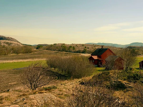 Une cabane traditionnelle en bois rouge soufflet colline rocheuse. Maison au design classique norvégien — Photo