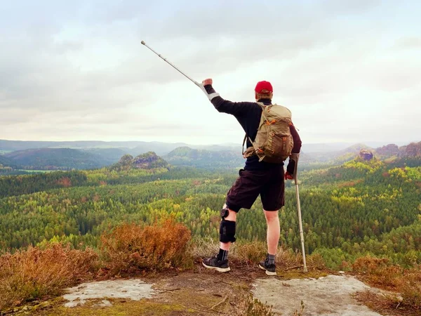 Nejvyšší vítězství. Muž s nohou v klecích koleno a berle pro stabilizaci a podporu chůze. — Stock fotografie