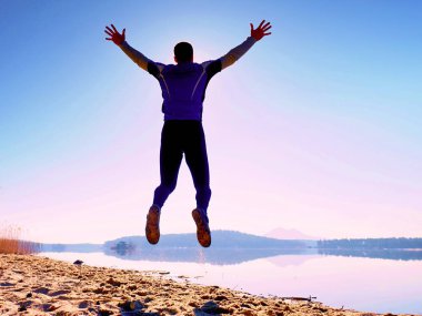 Adam atlama. Sporcu deli atlama ve kumsalda gündoğumu sırasında koşu