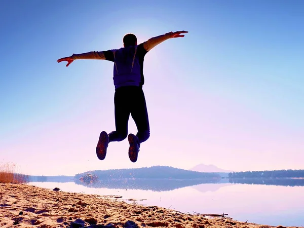 Adam atlama. Sporcu deli atlama ve kumsalda gündoğumu sırasında koşu