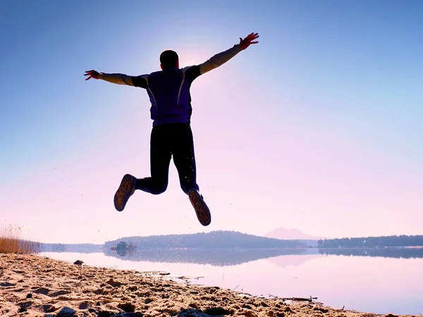 Adam atlama. Sporcu deli atlama ve kumsalda gündoğumu sırasında koşu