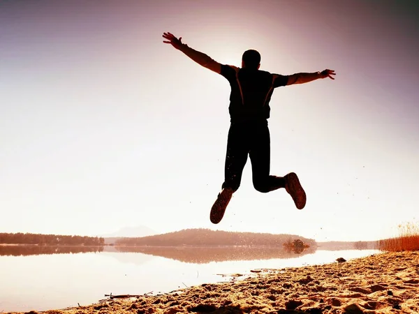 Прыгун. Мужчина безумно прыгал и бегал на пляже во время восхода солнца — стоковое фото