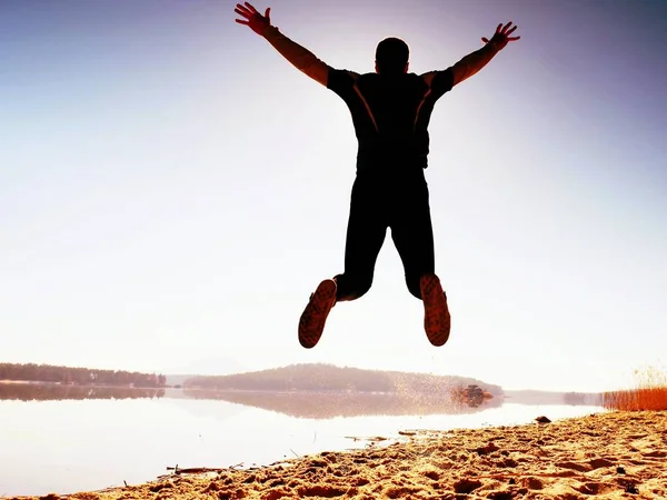 Прыгун. Мужчина безумно прыгал и бегал на пляже во время восхода солнца — стоковое фото