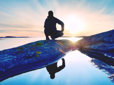 Uzun boylu backpacker deniz üzerinde açık güneşli gün doğumuna bak. Uzun yürüyüşe çıkan kimse uzun yürüyüşe çıkan kimse nefes kesici gündoğumu zevk