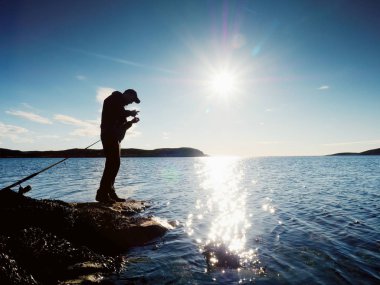 Çok yakın dikiz çalışma balıkçı için. Adam iterek yem kontrol ve çok denize atar. 