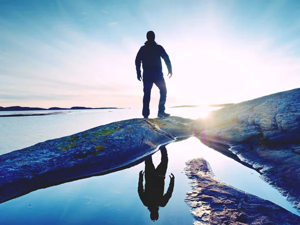 Uzun boylu backpacker deniz üzerinde açık güneşli gün doğumuna bak. Uzun yürüyüşe çıkan kimse uzun yürüyüşe çıkan kimse nefes kesici gündoğumu zevk