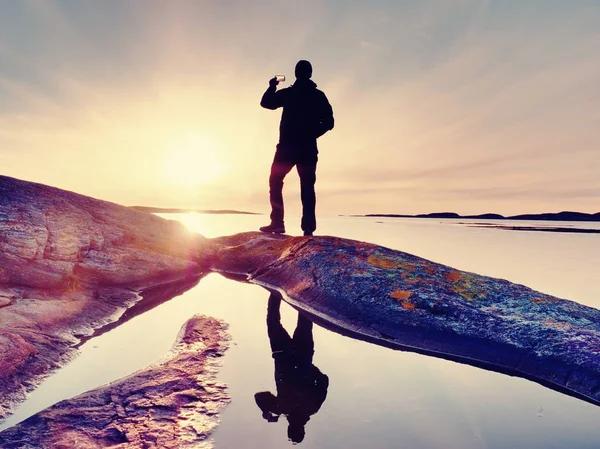 Cep telefonu dijital kamerada şaşırtıcı deniz manzara fotoğrafını çekmek turist adam.
