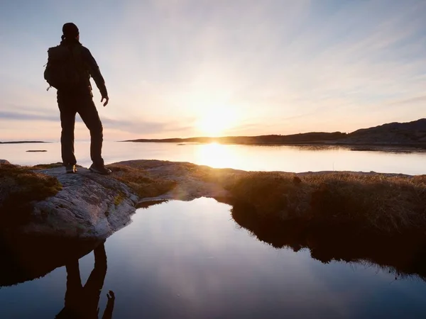 Alto mochilero ver claro amanecer soleado sobre el mar. Hiker Hiker disfrutar de impresionante amanecer — Foto de Stock