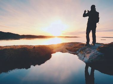 Cep telefonu dijital kamerada şaşırtıcı deniz manzara fotoğrafını çekmek turist adam.