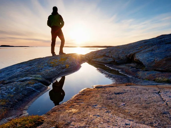 Silhouette uomo sulla scogliera sopra il mare. Turismo stand alone su roccia e guardare orizzonte del mare — Foto Stock