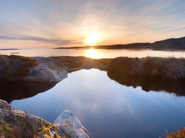 Hermoso paisaje marino. Espejo de puesta de sol en piscinas de agua en las rocas. Océano liso — Foto de Stock