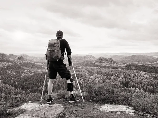 Engelli adam kaya üzerinde koltuk değneği. Elbise ve neopren aksesuar metal diz diş telleri ve adam tutun zarar diz koltuk değneği ön kolda. 