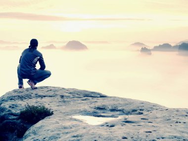 Adam sahanın kaya tepe üzerinde tek başına. Sonbahar güneş ufka izlerken uzun yürüyüşe çıkan kimse. Güzel anı doğa mucizesi. Renkli sis Vadisi'nde. Adam zam. Kişi siluet standı