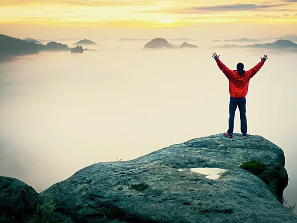 Uzun boylu turist dünyanın zirvesine kutlamak. Turuncu kalın sis Körüğü derin vadi. Rüya gibi daybreak — Stok fotoğraf