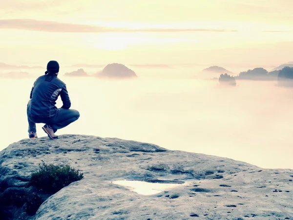 Adam sahanın kaya tepe üzerinde tek başına. Sonbahar güneş ufka izlerken uzun yürüyüşe çıkan kimse. Güzel anı doğa mucizesi. Renkli sis Vadisi'nde. Adam zam. Kişi siluet standı