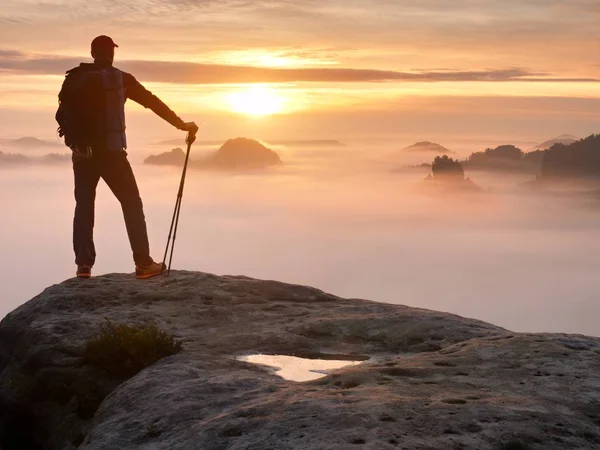 Silhouette uomo con pali in mano. Sunny vacanze primaverili e guida turistica soggiorno sulla scogliera tagliente di montagna . — Foto Stock