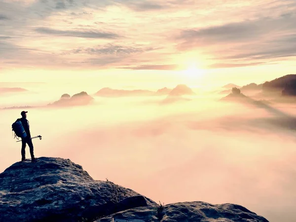 Männersilhouette mit Stangen in der Hand. Sonnenaufgang im Frühling und Reiseführer bleiben auf scharfen Klippen des Berges. — Stockfoto