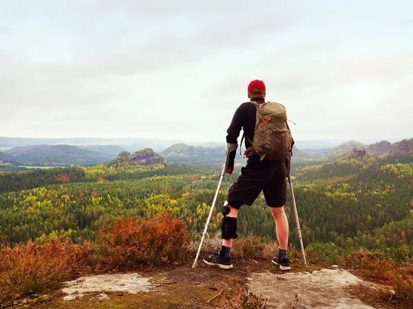 Człowiek wycieczkowicz noszenie podtrzymujące nogi klamra i gainst cruthes. Naturalny Las park — Zdjęcie stockowe