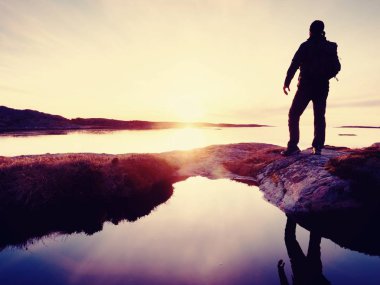 Fiyatı Polonyalılar ve sportif sırt çantası ile koyu spor giyim içinde. Kayalık sahil sahil şeridi iz. Yalnız turist keyfini çıkarın