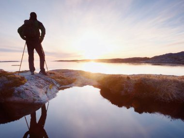 Uzun boylu backpacker deniz üzerinde açık güneşli gün doğumuna bak. Uzun yürüyüşe çıkan kimse uzun yürüyüşe çıkan kimse nefes kesici gündoğumu zevk