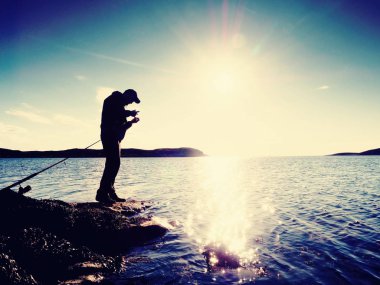 Çok yakın dikiz çalışma balıkçı için. Adam iterek yem kontrol ve çok denize atar. 