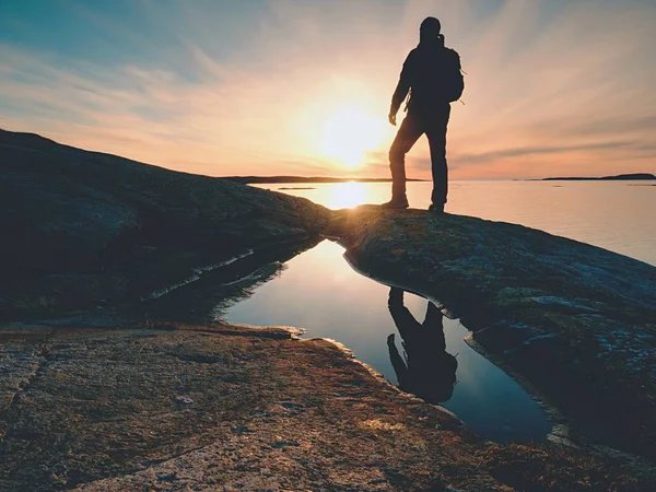 Silueta hombre en el acantilado sobre el mar. Puesto turístico solo en la roca y ver el horizonte del mar — Foto de Stock