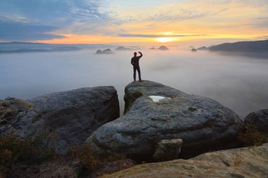 Arka adam siluet kayalık tepe üzerinde keskin. Uzun yürüyüşe çıkan kimse tatmin manzarasının tadını çıkarın. Kayalık uçurum üzerinde uzun boylu adam