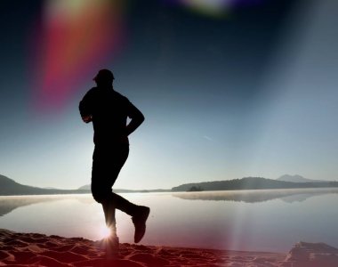 Kaçak ışık objektif. Sabah güneş karşı adam siluet egzersiz.