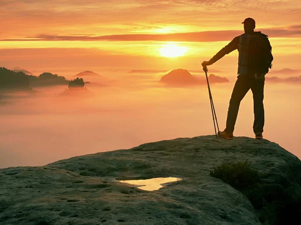 Silhouette uomo con pali in mano. Sunny vacanze primaverili e guida turistica soggiorno sulla scogliera tagliente di montagna . — Foto Stock