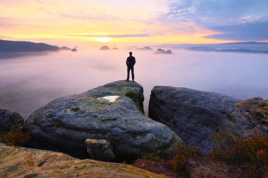 Arka adam siluet kayalık tepe üzerinde keskin. Uzun yürüyüşe çıkan kimse tatmin manzarasının tadını çıkarın. Kayalık uçurum üzerinde uzun boylu adam