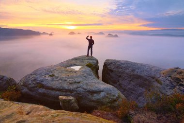 Uzun yürüyüşe çıkan kimse Vadisi yukarıda rock ucunda. Adam sabah puslu ve sonbahar vadiye parlak sabah güneş göz kulak.