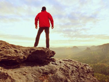 Uzun yürüyüşe çıkan kimse bir dağın tepesinde duran ve gündoğumu zevk. Güzel an 
