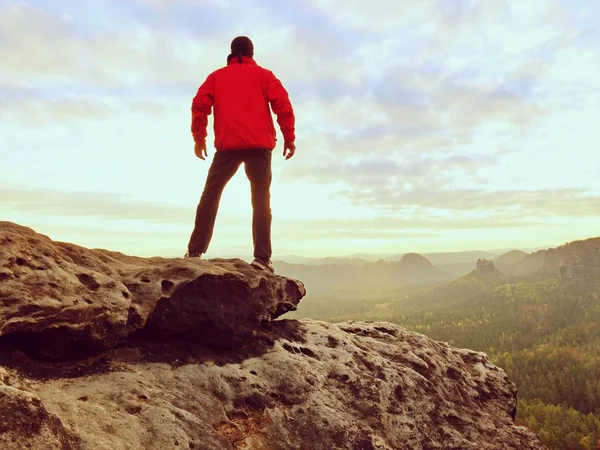 Uzun yürüyüşe çıkan kimse bir dağın tepesinde duran ve gündoğumu zevk. Güzel an 