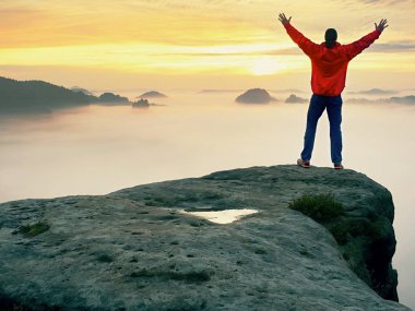 Dağ zirvesi. Mutlu bir adam jest silah kaldırdı. Komik uzun yürüyüşe çıkan kimse ile yükseltilmiş eller havaya