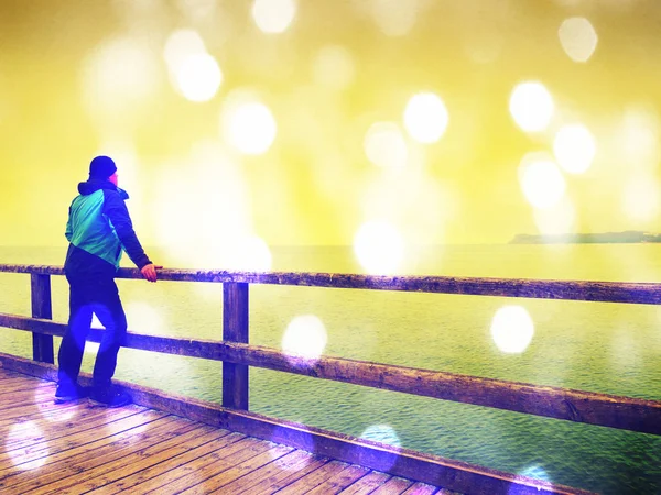 Adam uzun turistik köstebek, sonbahar soğuk sabah. Küpeşte, turist. Ahşap masa, kabinlerine pürüzsüz deniz üstünde ıslak. 