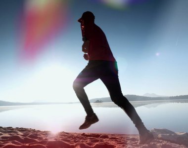 Kaçak ışık objektif. . Çalışan adam. Koş, sporcu adam kumlu bir plaj üzerinde gündoğumu sırasında koşu.