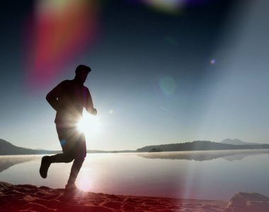 Kaçak ışık objektif. Sabah güneş karşı adam siluet egzersiz.