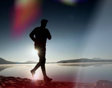 Kaçak ışık objektif. Sabah güneş karşı adam siluet egzersiz.