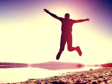 Adam atlama. Sporcu deli atlama ve kumsalda gündoğumu sırasında koşu