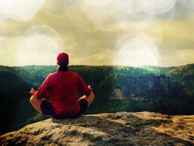 Yoga poz dağın tepesinde oturan adam. Egzersiz yoga nefes kesen manzarası ile kenarında 