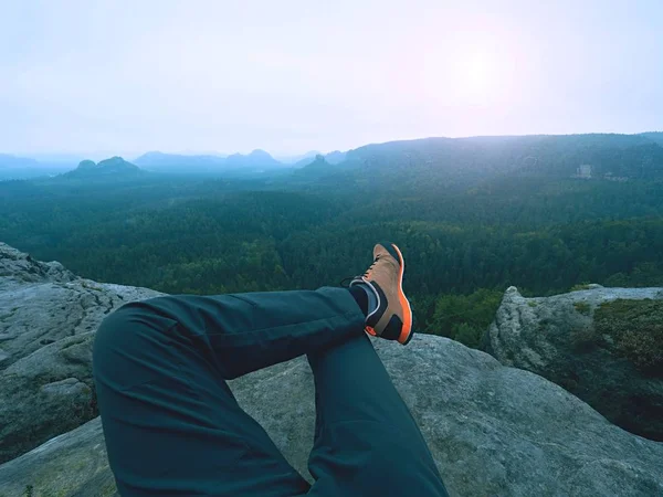 Hombre cansado excursionista acostarse y disfrutar de la vista en el paisaje sobre sus piernas cansadas en botas turísticas — Foto de Stock