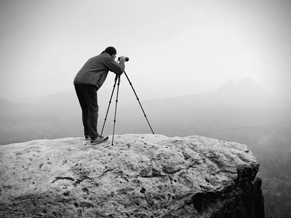 Fotógrafo de vida silvestre en la cumbre de montaña funciona. Al hombre le gusta viajar y fotografiar, tomar fotos — Foto de Stock