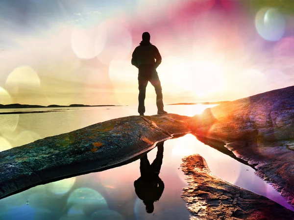 Turist adam cep telefonu dijital kamerada şaşırtıcı deniz manzara fotoğrafını çekmek. Pürüzsüz Okyanusu yakınlarındaki bir kaya üzerinde uzun yürüyüşe çıkan kimse kalmak.