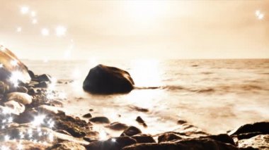 Objektif kusur. İçinde parlak ve ışıltılı dalgalar deniz ve kayalar üzerinden savunduğun twilight saat su. Pembe günbatımı kayalık sahil, Baltık Denizi.