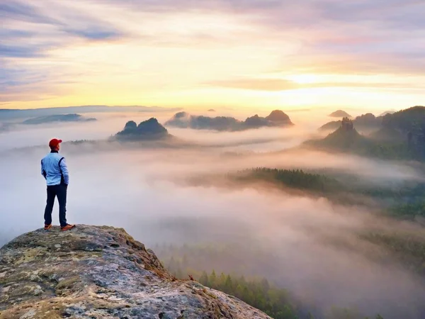 Yorgun backpacker İzle Bahar daybreak rocky Dağları'nda. Beyzbol kap ve Beyaz gömlekli uzun yürüyüşe çıkan kimse. 