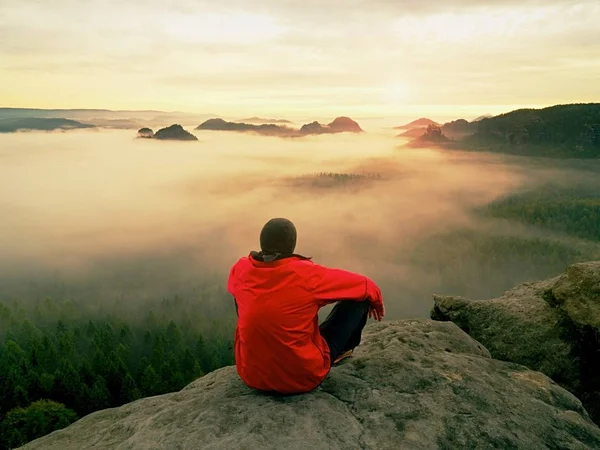 Hayattan zevk. Adam siyah pantolon, ceket ve karanlık kap içinde oturup Cliff'in kenar ve yatay olarak seyir üzerinde