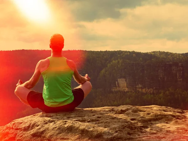 Az ember, meditál, Lotus jelentenek a sziklás sziklán. Sportsman gyakorló jóga-csúcs — Stock Fotó