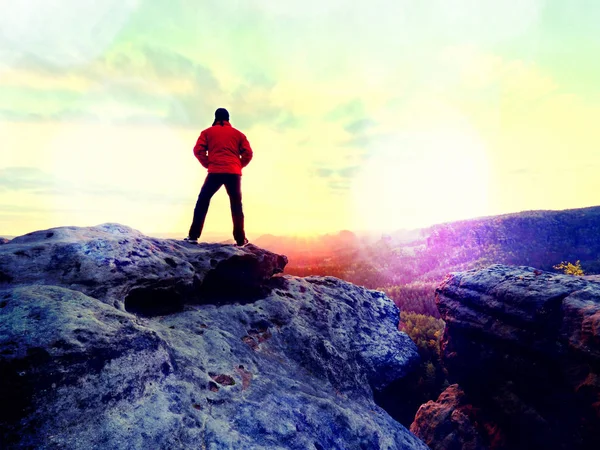 鋭い崖の上の赤の屋外ジャケットの男性の図です。山の秋の初め — ストック写真